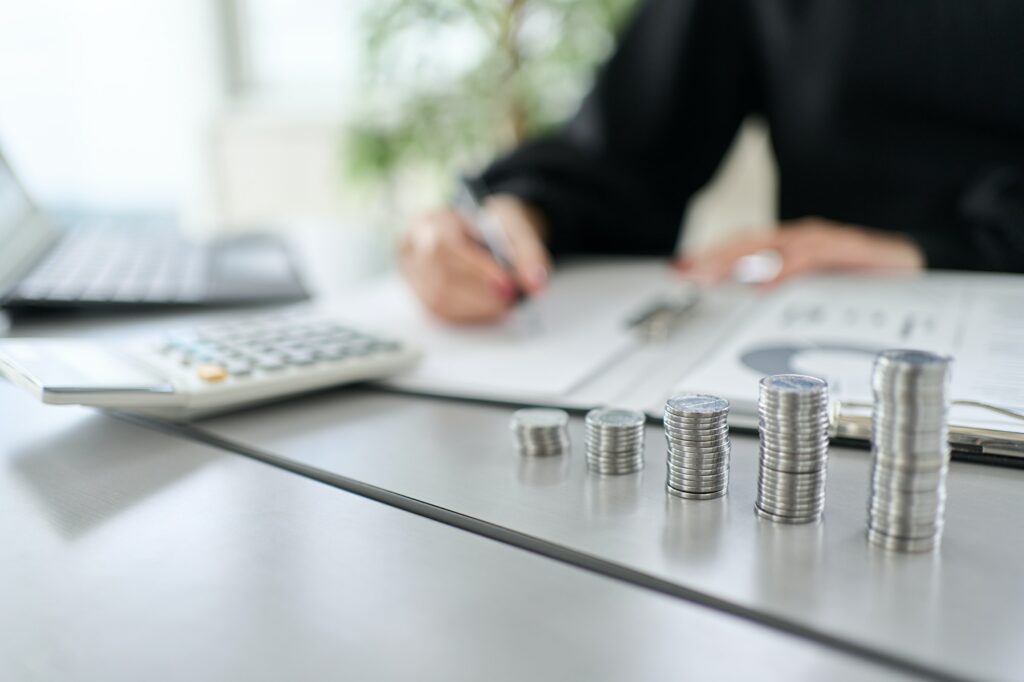 A woman studying investment and a coin stack